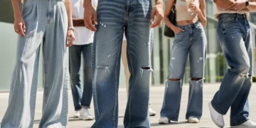 Diverse individuals modeling comfortable and trendy denim styles for 2026, including wide-leg and relaxed-fit jeans, in an urban environment.