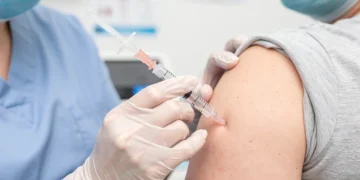 Healthcare professional administering flu vaccine to an adult patient's arm