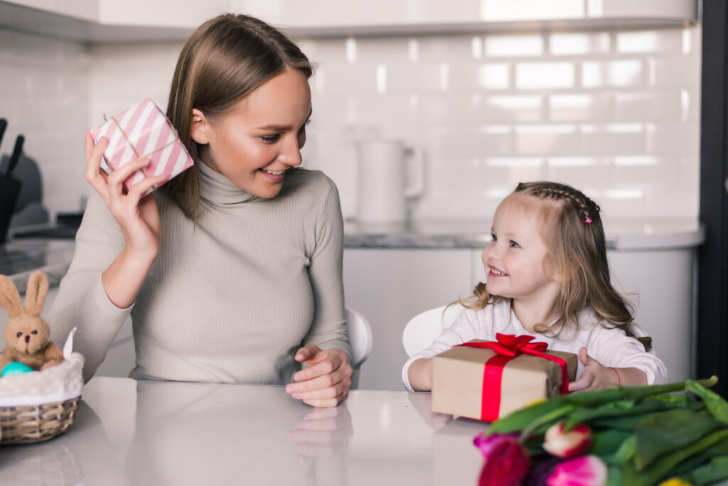young pretty mother daughter with gifts box kitchen