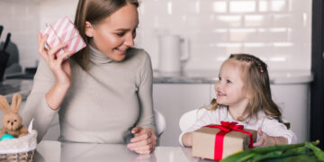 young pretty mother daughter with gifts box kitchen
